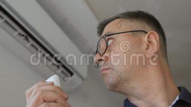 一个戴眼镜的男人，拿着遥控器，打开家里的空调。 分离系统连接到